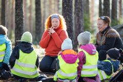 Varhaiskasvatuksen opettaja Ulla Rutanen ja lastenhoitaja Lissu Bamberg vetävät opetustuokiota eskareiden ja vähän pienempien metsäryhmälle. KUVA: Marjaana Malkamäki