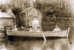 Mor och tre barn i rodbåt vid vattenbryn i Brändö, foto: SLS, Vasa