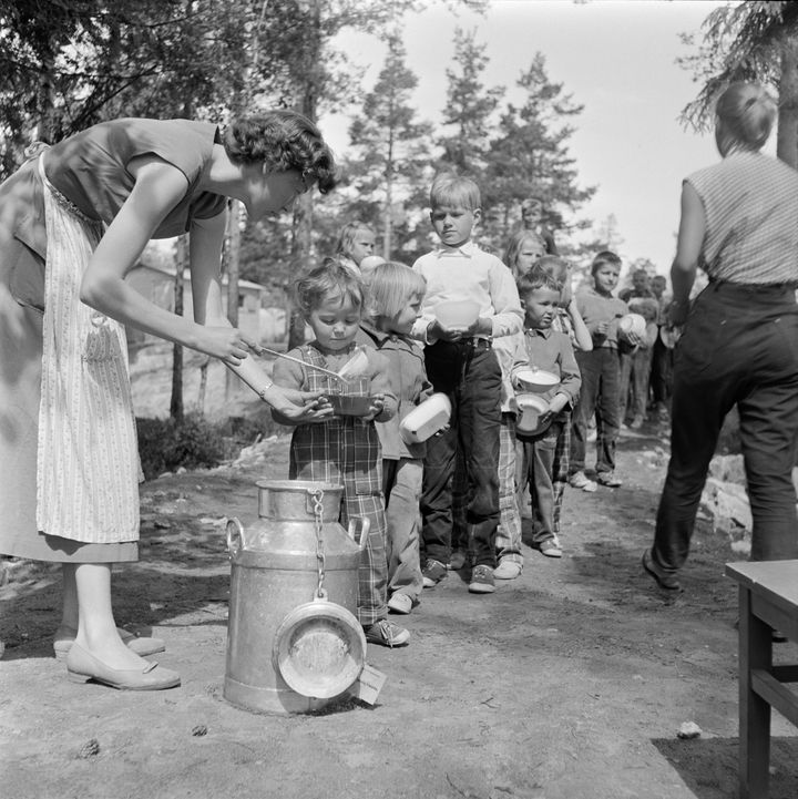 Nainen jakaa ruokaa leikkipuistossa 1950. Kuva:kaupunginmuseon kuva-arkisto.