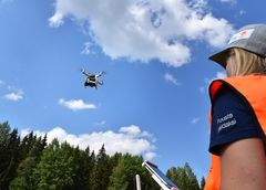 Stora Enson metsäasiantuntija Saana Pulkkinen lennättää dronea.