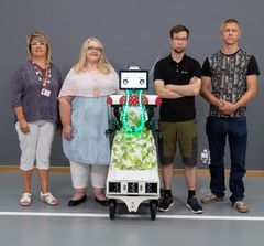 Robotin kehittämisprojektin avainhenkilöitä Ursula-robotin kanssa. Vasemmalta: Tarja Viemerö ja Hannakaisa Haanpää Kangasalan kaupungilta sekä Eetu Friman ja Tuomas Salomaa Tampereen yliopiston Mekatroniikan tutkimusryhmästä. Kuva: Ismo Santapukki