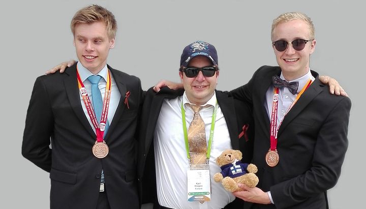Vasemmalta: Tomi Ruosteoja, joukkueen valmentaja Kjell Knapas ja Santeri Simanainen. Kuvassa lisäksi joukkueen maskotti Ilmari. Kuva: Miia Mäntymäki