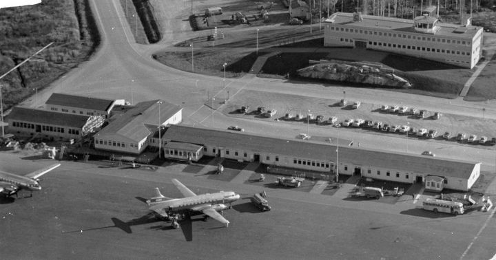 Helsingin lentoasemaa 1950-luvun puolivälissä, matkustajaterminaali. Taustalla lennonvarmistusrakennus. Kuva: Valokuvaamo Salminen Maunula / Suomen Ilmailumuseo.