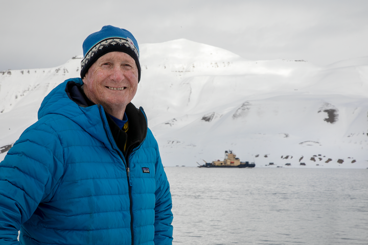 Professori Jeff Welker Huippuvuorilla, taustalla jäänmurtaja Oden, kuva Marcel Schütz / Svalbard Photography