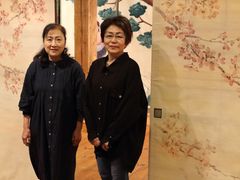 Silkki- ja paperikukkataiteilija Yuko Sato (vas.) sekä näyttelyn fusumapaperimaalaukset tehnyt Yoshiko Shimada. Kuva: Anssi Taskinen.