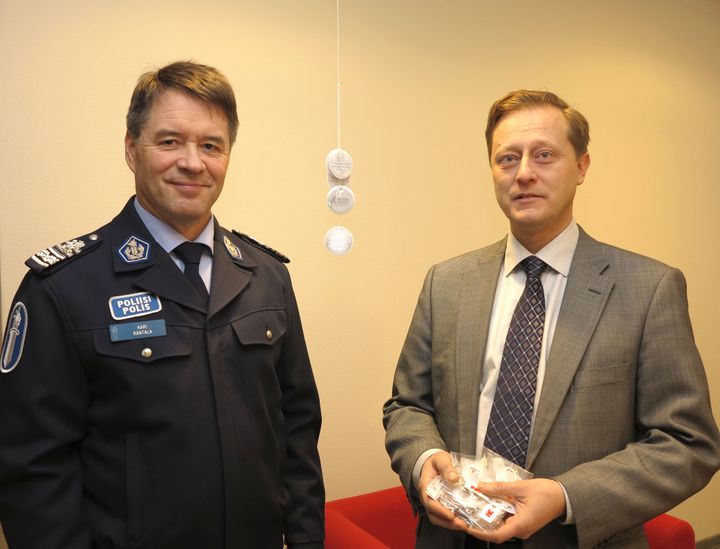 Vakuutusyhtiöiden liikenneturvallisuustoimikunnan varapuheenjohtaja Markus Nieminen (vas.) luovutti Liikkuvan poliisin päällikölle Kari Rantalalle 10 000 heijastinta jaettavaksi sen tarpeessa oleville jalankulkijoille.