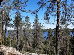 Kalliojyrkänteen päältä avautuu maisema sinisenä kimmeltävälle Oulujärvelle.