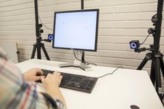 Optinen liikkeentunnistusjärjestelmä tallentaa käsien ja sormien tarkat liikkeet kirjoittamisen aikana. Silmänliikelasit seuraavat koehenkilön katsetta näytön ja näppäimistön välillä. Kuva: Aalto-yliopisto/Mikko Raskinen