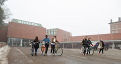 Opiskelijoita polkupyörineen Seminaarinmäen kampuksella Jyväskylän yliopiston päärakennuksen edustalla.