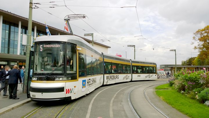 Artic Würzburgin kaupunkiliikenteessä. Vaunu on saanut ulkopintaansa uuden värityksen lisäksi kyytiä kokeilemaan kannustavat tekstiteippaukset.