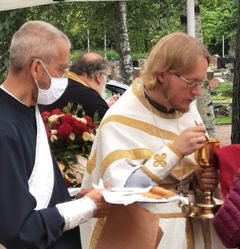 Aiemmin kasvosuojaa on suositeltu kirkossa käytettäväksi vain riskiryhmiin kuuluvien tapaamisissa. Muu käyttö on perustunut henkilökohtaiseen harkintaan. Kuvassa diakoni jakamassa ehtoollista yhdessä papin kanssa kasvosuojus kasvoillaan. Kuva: Vlada Wahsltén / Helsingin ortodoksinen seurakunta.