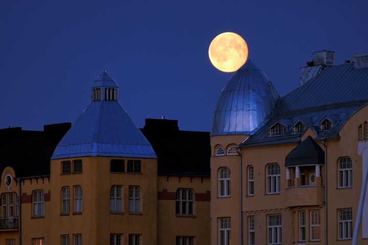 Kuu nousee Katajanokan kattojen yllä. Kuva: Visit Helsinki.