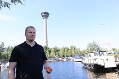 Wiiste Oy:n toimitusjohtaja Toni Luopajärven kädessä näkyy uusi betonivaluun upotettava IoT-anturi. Takana kohoava Näsinneula edusti aikansa huipputeknologiaa ja valittiin vuoden 1970 betonirakenteeksi.