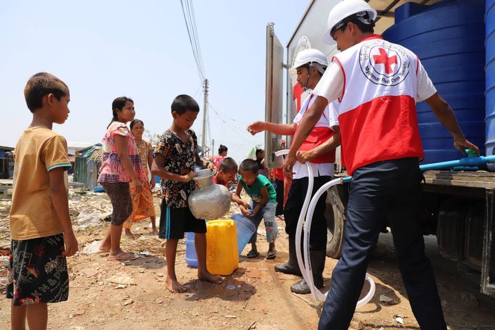 Frivilliga från Myanmars Röda Kors delar ut rent vatten och informerar om förebyggande av smittsamma sjukdomar på ett område i Rakhine som drabbats av cyklonen Mocha.  Bild: Röda Korset i Myanmar