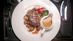 Pääruoaksi nautittiin Black Angus -sisäfileepihviä, paistettuja herkkusieniä ja sipulia, paahdettuja valkosipuliperunoita sekä konjakki-viherpippurikastiketta. Kuva: Ilmari Heinäjärvi, Third Point Photography