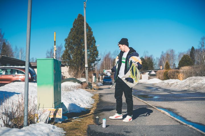 Taiteilija Jon Gredmark tulkitsee ja maalaa valitut ideat sähkökaappien kylkeen Ristinummella. Kuvaaja: Ilkka Nyqvist.