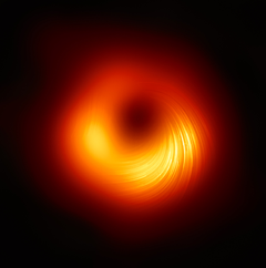 Kuvassa M87-galaksin supermassiivinen musta aukko polarisoidussa valossa. Tämä musta aukko sijaitsee 55 miljoonan valovuoden etäisyydellä Maasta, ja sen massa vastaa 6,5 miljardin Auringon massaa. Kuvassa näkyvät viivat kuvaavat polarisaation suunnan, joka puolestaan riippuu mustaa aukkoa ympäröivän magneettikentän suunnasta. © EHT Collaboration