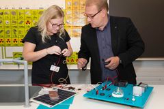 Fysiikan opettaja Sanna Tervakoski kytkee piuhoja ja sähköurakoitsija Sami Suomilammi  opastaa.
