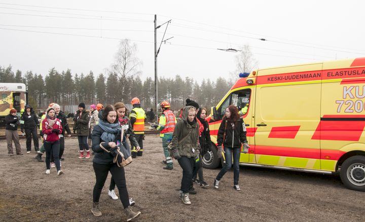 Onnettomuusjunan matkustajia siirretään pois onnettomuuspaikalta.