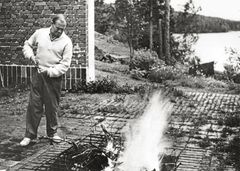 Alvar Aalto hoitaa ”elämän sydäntä” pihalla 1960-luvun alussa. Istutukset talon ulkopuolella ja rikkakasvit pation tiilien välissä kukoistavat. Kuva: Alvar Aalto -säätiö