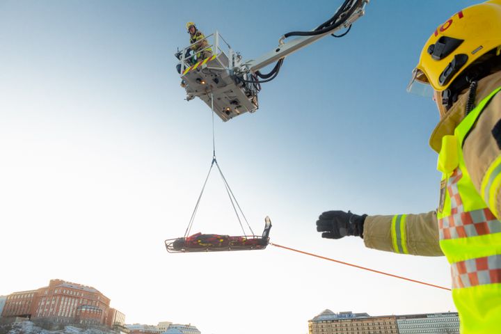 Helsingin pelastuslaitoksen palomies potilaan siirrossa.