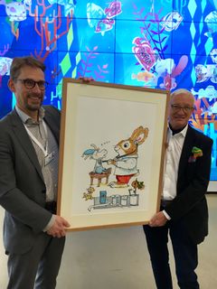 Toimialajohtaja Jari Petäjä ja lastenkirjailija Huck Scarry teoksen luovutustilaisuudessa Uudessa lastensairaalassa.