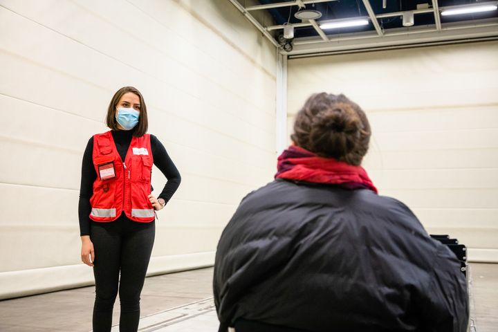 Punaisen Ristin kouluttamat vapaaehtoiset avustavat koronarokotuksissa.  Kuva Sakari Piippo / Punainen Risti