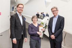 Nationalgalleriets 700 000:e besökare år 2017 var Kaarina Laine, som fick blommor från museichef Leevi Haapala och Nationalgalleriets generaldirektör Risto Ruohonen. Foto: Nationalgalleri / Pirje Mykkänen