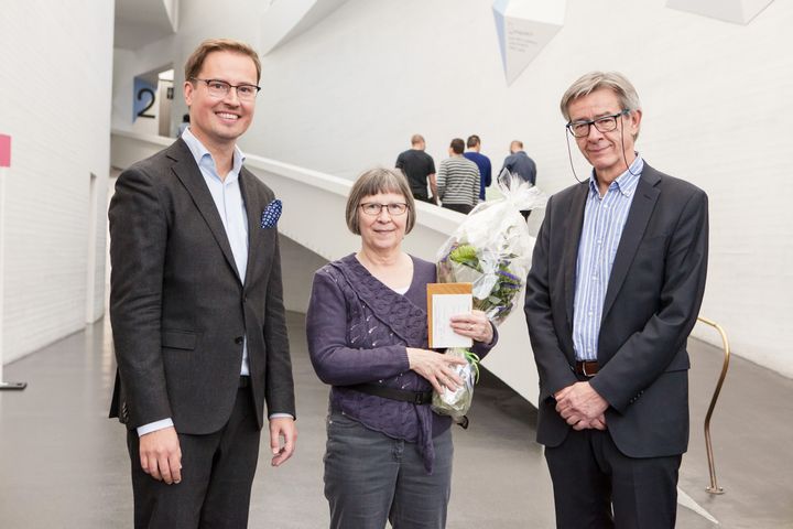 Nationalgalleriets 700 000:e besökare år 2017 var Kaarina Laine, som fick blommor från museichef Leevi Haapala och Nationalgalleriets generaldirektör Risto Ruohonen. Foto: Nationalgalleri / Pirje Mykkänen