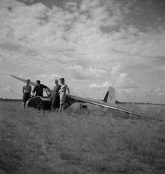 Neljä nuorta miestä Hyvinkään lentokentällä purjelentokoneen edessä, 1950-luku. Kuva: Niilo Ristamo / Hyvinkään kaupunginmuseo
