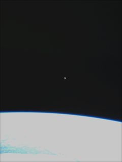 16. joulukuuta 2018 otettu kuva Kuusta ja Maasta. Suomi 100:n kamerassa on laajakulmalinssi, koska se on suunniteltu Maan päällä olevien laajojen ilmiöiden – ennen kaikkea revontulten – kuvaamiseen. Siksi Kuu näyttää kuvassa pieneltä.  Koska valotus on säädetty Kuun mukaan, Maa on kuvassa ylivalottunut. Ilmakehä näkyy kuvassa selvästi ohuena, sinisenä kaarena. Kuva: Aalto-yliopisto