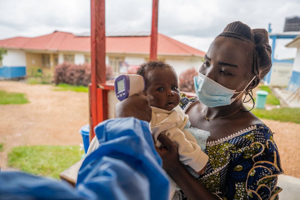 CH11590948_Marléne (25) holds her daughter Deborah (2 months) as she gets a temperature check.jpg
