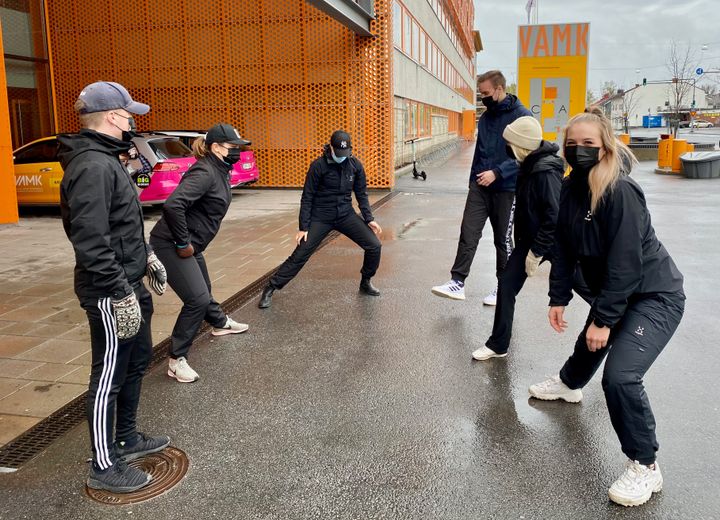 Paavo Sormunen, Ulrika Palmberg, Silvia Musikka, Arttu Kauppi, Emilia Paasonen ja Jenna Laitila venyttelevät VAMKin pihassa ennen yhteistä reippailua.