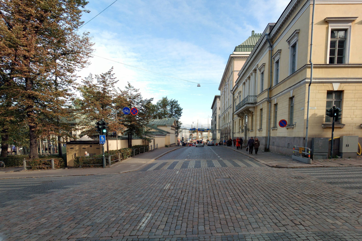 Kuva Eteläesplanadilta Ravintola Kappelin kohdalta, johon saadaan kokeilun myötä jalkakäytävä molemmille puolille katua ja jalkakäytävästä selkeästi eroteltu pyörätie. (Kuva Helsingin kaupunki 2019)