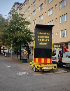 Kadulle on tuotu noin neljä metriä korkea Led-näyttö, jossa muistutetaan kadun sulkemisesta. Peräkärryllä liikkuva näyttö on varustettu aurinkopaneeleilla. Kuva: Ramudden