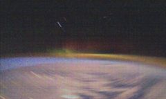 22. tammikuuta 2019 otettu valokuva revontulista, jotka näkyvät usvaisena vihreänä pystyrakenteena kuvan keskellä, Maan horisontin yläpuolella. Revontulten ikuistaminen pienellä satelliitilla on haastavaa satelliitin pyörimisen vuoksi, mikä rajoittaa pitkien valotusaikojen käyttöä. Tarkkasilmäiset huomaavat revontulikuvassa myös Kotkan tähtikuvion kirkkaimmat tähdet sekä Lapin ja Murmanskin kaupunkien valoja hohtamassa pilvien alla. Kuva: Aalto-yliopisto