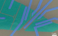Elektronimikroskooppikuva näytteestä, jossa vihreät kerrokset kuvaavat grafeenia, joka on harmaana kuvatun piidioksidin päällä. Keskellä olevaa, heikosti grafeeniin kytkettyä elektrodia käytetään lomittuneiden elektronien tuottamiseen. Kuva: Kylmälaboratorio, Aalto-yliopisto.