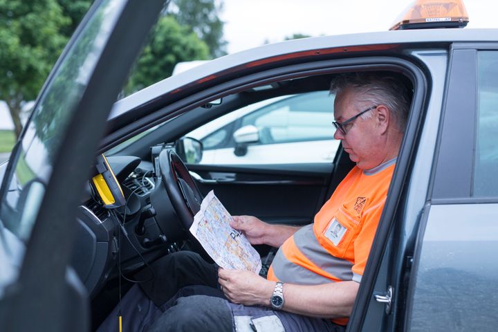 Kartoittaja Maanmittauslaitoksen autossa. Kuva: Julia Hautojärvi