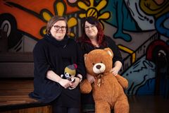 Turo-pandalla on nuoriso-ohjaaja Anne Lammisen (vas.) kutoma pipo ja kaulahuivi. Nuoriso-ohjaaja Laura Plosilan sylissä on nuorisotalo Sumpun nuorille tärkeä Rane-nalle, jonka kanssa nuoret halailevat, painivat ja pelaavat korttia. Kuva: Vaasan kaupunki / Rauli Lehto