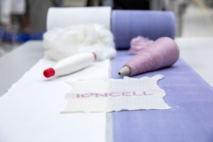 Valkoisista ja sinisistä rullapyyhkeistä tehtyä Ioncell-kuitua, lankaa sekä neulosnäyte. Ioncell-kuidun lujuuden ansiosta siitä tehdyt tekstiilit on mahdollista kierrättää useita kertoja laadun kärsimättä. Kuva: Mikko Raskinen / Aalto-yliopisto