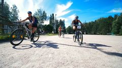 Osallistujat liikkuvat kolmen henkilön joukkueina pääsääntöisesti polkupyörillä. Kuva: Joenrinne Films