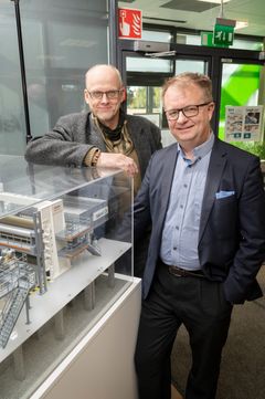 OptiCalender Multinips uppfinnare. Elomatics innovationsexpert, DI Pekka Koivukunnas (till vänster) och Aalto-universitetets arbetslivsprofessor, TD Juha Lipponen bredvid en miniatyr av pappersmaskinen som utnyttjar uppfinningen i Valmets aula i Träskända. Bild: Markus Sommers