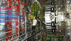Hiukkasfyysikko Santeri Laurila taustallaan CMS-kokeen mittauslaitteistoa. CMS-koeasema sijaitsee LHC-hiukkastörmäyttimen tunnelissa Cernissä. Kuva: Juska Pekkanen.