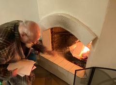 Pehtoori Göran Tornaeus takkahuoneessa tulta ruokkimassa.