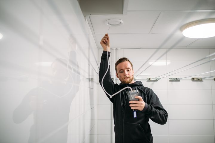 Trio Ilmastoinnin Janne Louho tarkistaa ilmastointikanavien toimivuutta helsinkiläisessä taloyhtiössä.