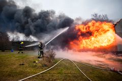 Sopimuspalokuntalaisia sammuttamassa harjoituksissa poltettavaa asuinrakennusta