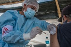 Sairaanhoitaja Maryuri Garcia Valladares antaa koronarokotteen venezuelalaiselle siirtolaiselle Perun ja Ecuadorin rajalla maaliskuussa 2022. Perussa koronavirukseen on kuollut yli 200 000 ihmistä. Kuva Max Cabello Orcasitas, Lääkärit Ilman Rajoja.