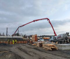 Betoniauto valuttaa betonia rakenteilla olevan pysäköintilaitoksen perustuksiin rakennustyömaalla.