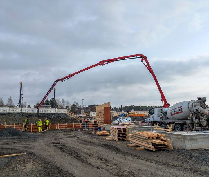Betoniauto valuttaa betonia rakenteilla olevan pysäköintilaitoksen perustuksiin rakennustyömaalla.