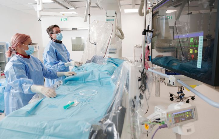 Sydänsairaala Novan toimenpidesalissa sairaanhoitaja ja kardiologi valmistautuvat sydänpotilaan sepelvaltimoiden varjoainekuvaukseen.